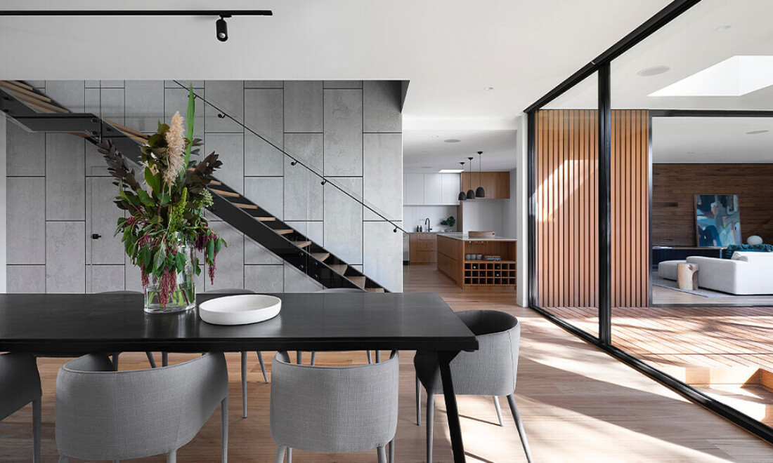 Wide photo of architecturally designed home with grey, black and timber finishes